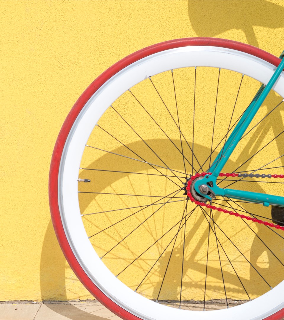 Ett hjul på en cykel. Gul bakgrund.
